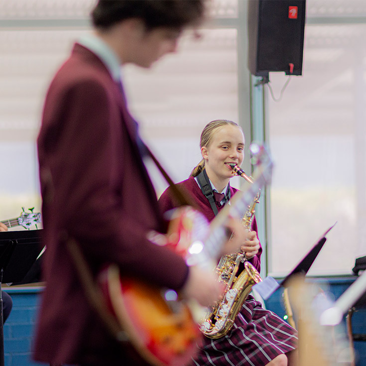 Two Bede Polding Catholic College Sth Windsor students practising guitar and saxaphone